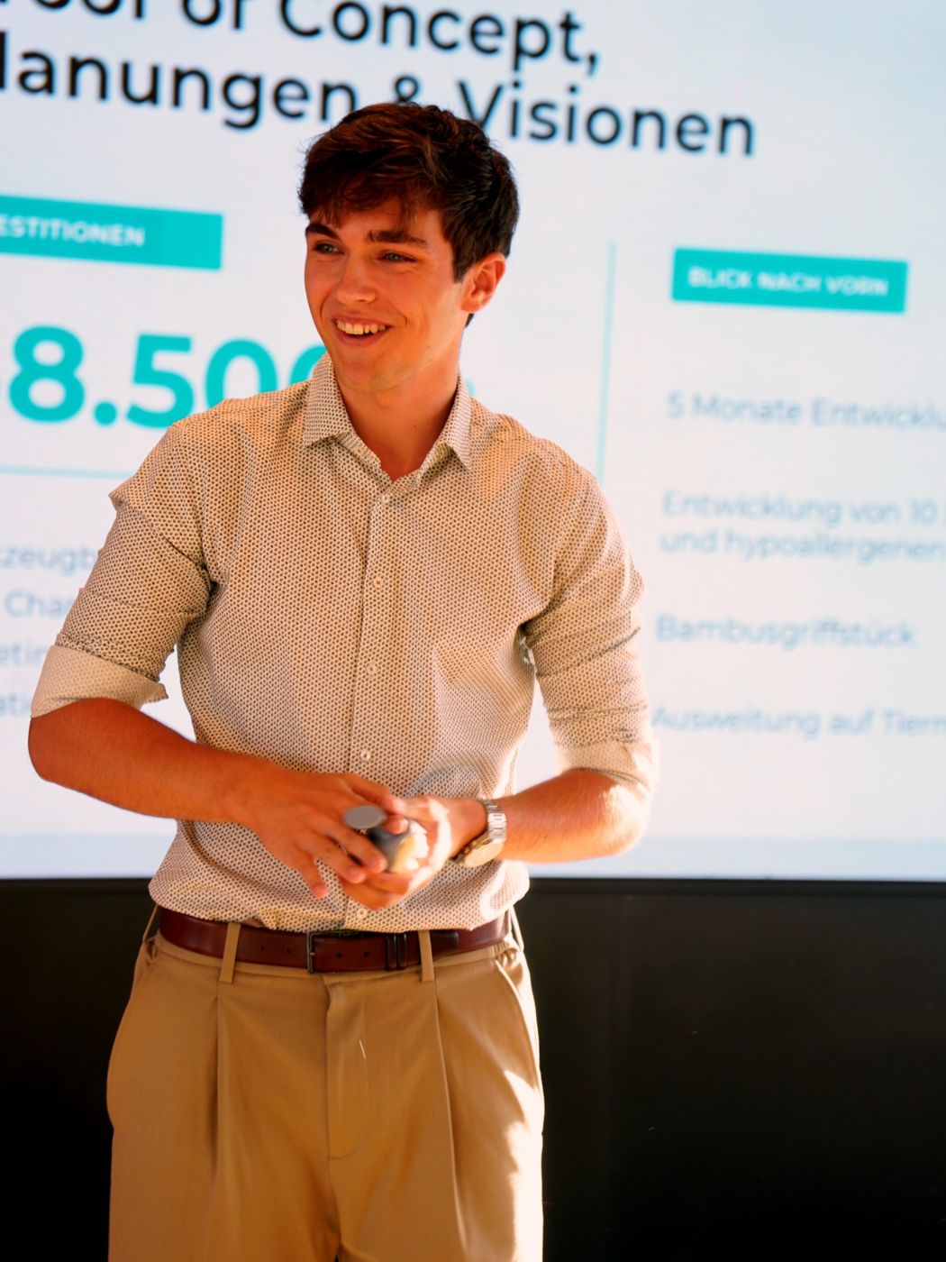 Gründer Lasse Bellmann lacht bei seinem Pitch in Würzburg und hält den Dalera-Prototyp